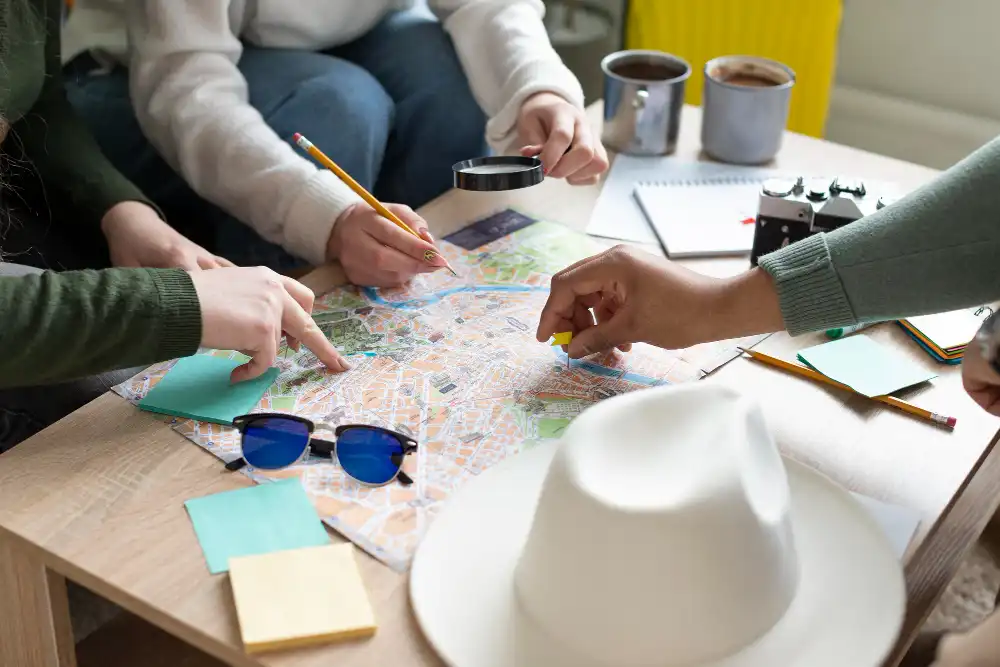Grupo planejando viagens rápidas de fim de semana em São Paulo, usando mapa e acessórios de viagem na mesa, ideal para quem quer otimizar roteiros de última hora.