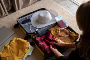Mulher organizando roupas e acessórios em uma mala de viagem para montar uma mala inteligente, ideal para viagens curtas e longas com dicas de o que levar.
